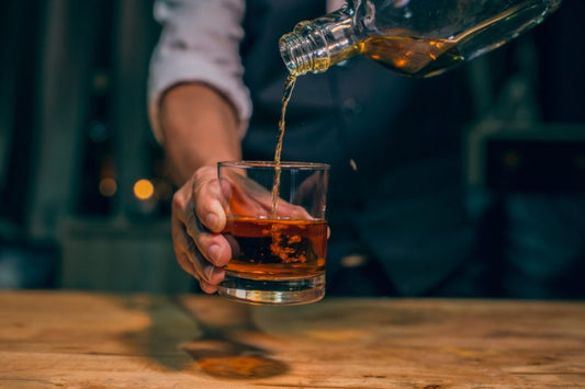 bartender pouring hooten young whiskey into glass