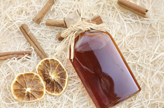 bottle of spiced rum with cinnamon sticks and dried citrus