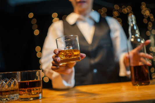 bartender offering glass of frey ranch bourbon in bar