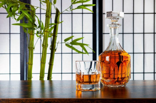 japanese whiskey in a glass by plant and bottle and screen