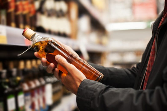 man holding a bottle of affordable whiskey