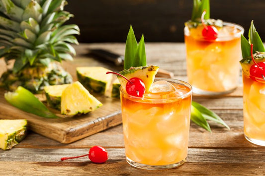 pineapple rum cocktails on wooden table with sliced pineapples
