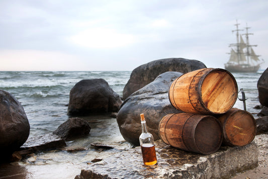 rum bottle next to several barrels