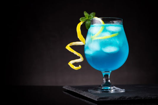 amf cocktail in glass with ice and lemon against a black background