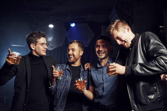 group of friends with whiskey glasses drinking clear water distillery whiskey