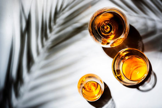 overhead shot of three glasses of armagnac with leaf shadows