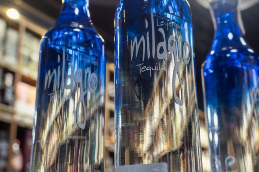 three bottles of milagro silver tequila on bar