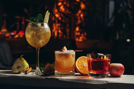 three glasses of tequila cocktails with garnishes on bar