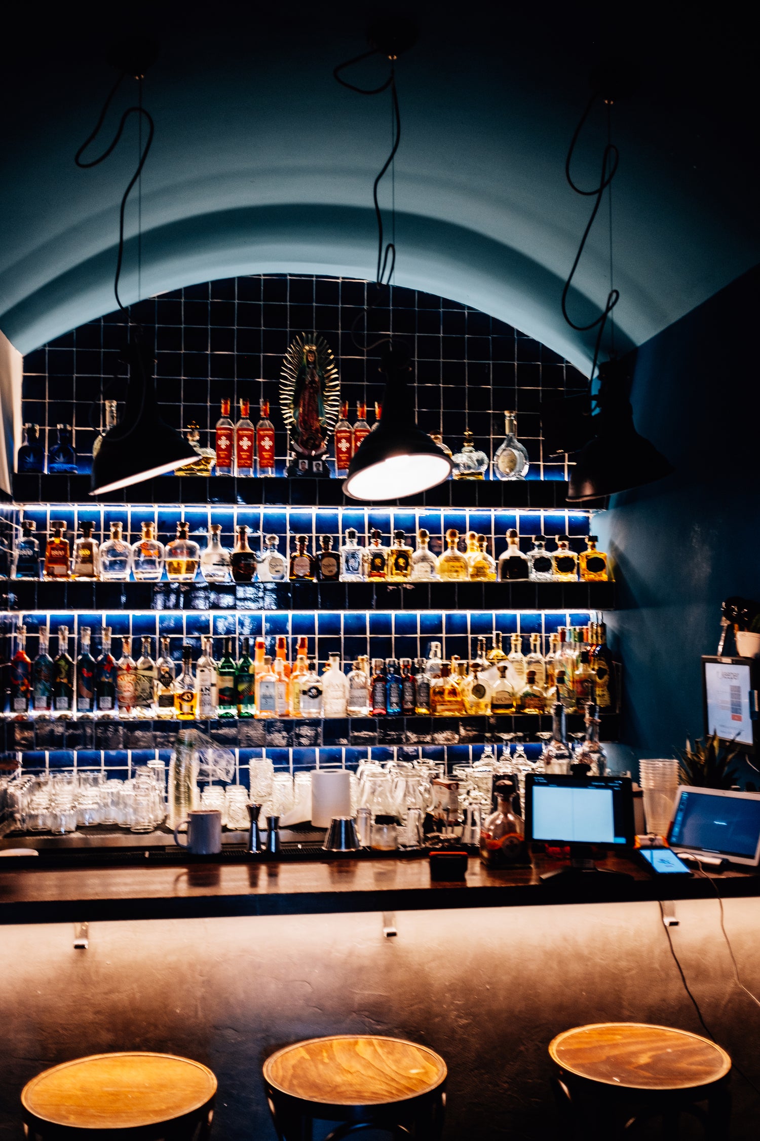 Backlit bar with alcohol bottles lined up on shelves