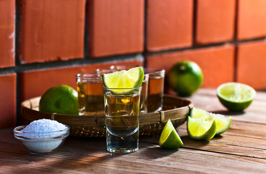 tequila 512 shots with salt and limes on wooden counter