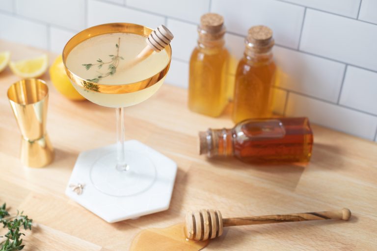 bees knees cocktail with ingredients on counter 