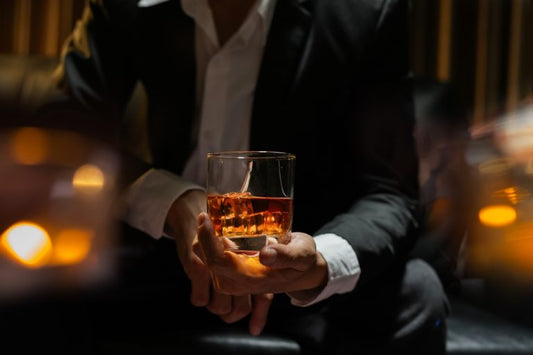 businessman holding glass of jura whiskey in bar