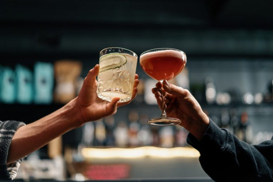 friends cheering tequila cocktails in a bar