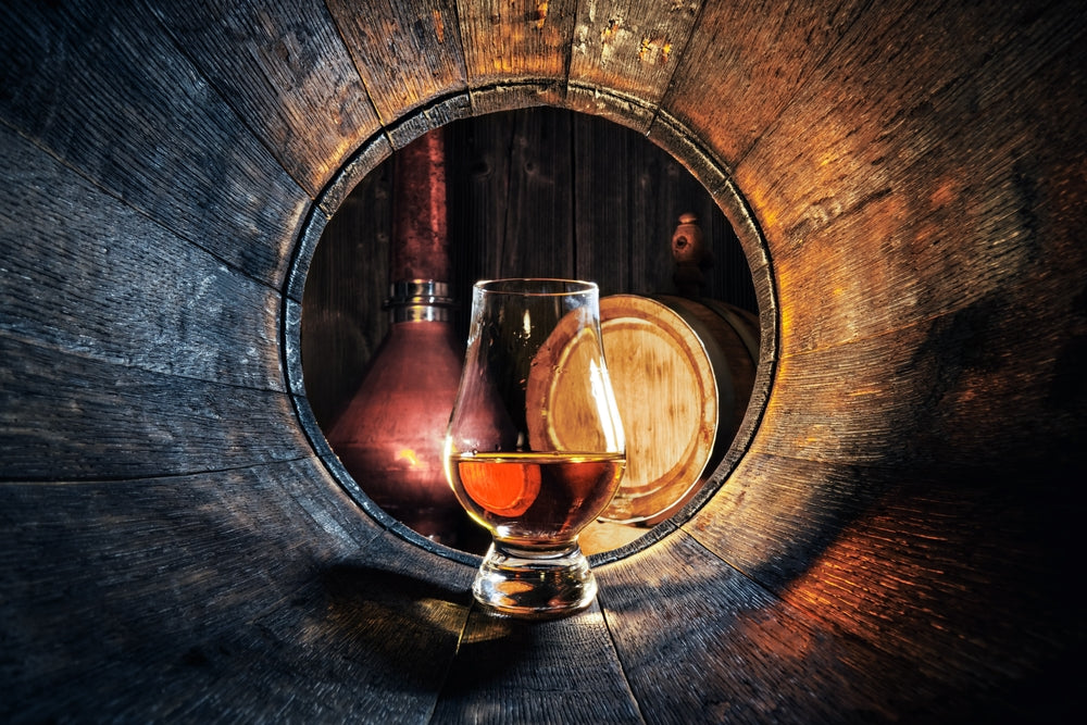 glass of middle west spirits whiskey inside a barrel