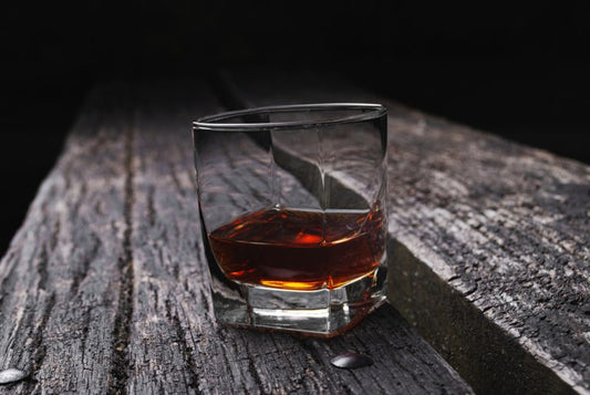 glass of rye whiskey on wooden table