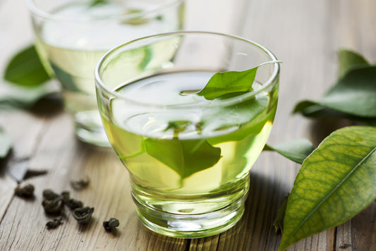 green tea shot in two glasses with mint leaves