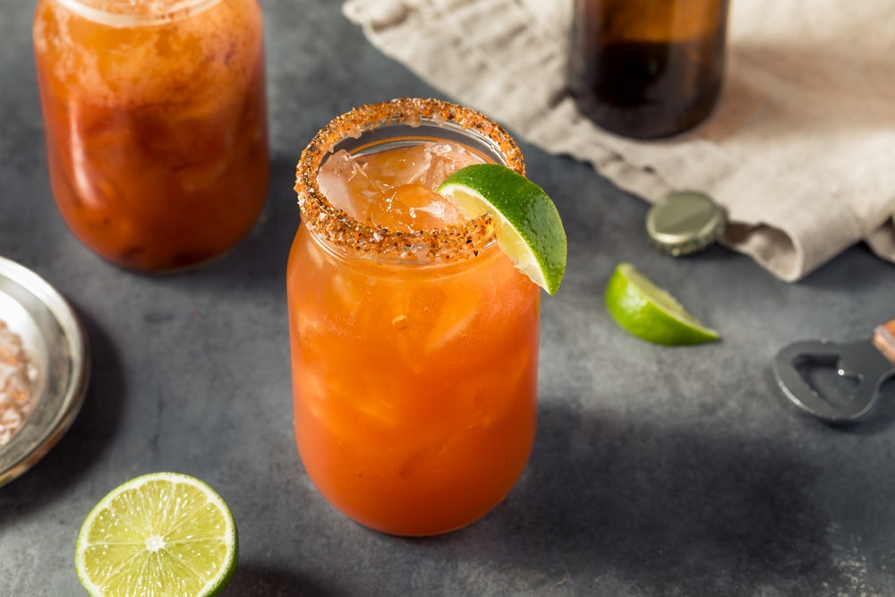 michelada cocktails with ice and lime in mason jar