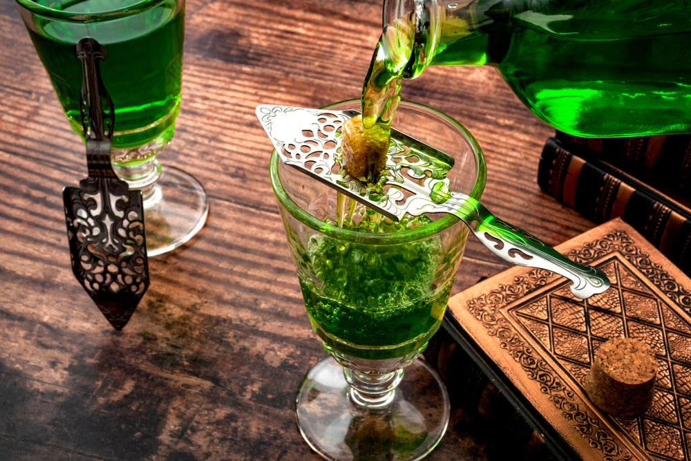 absinthe cocktail with ice and mint and liquor bottle