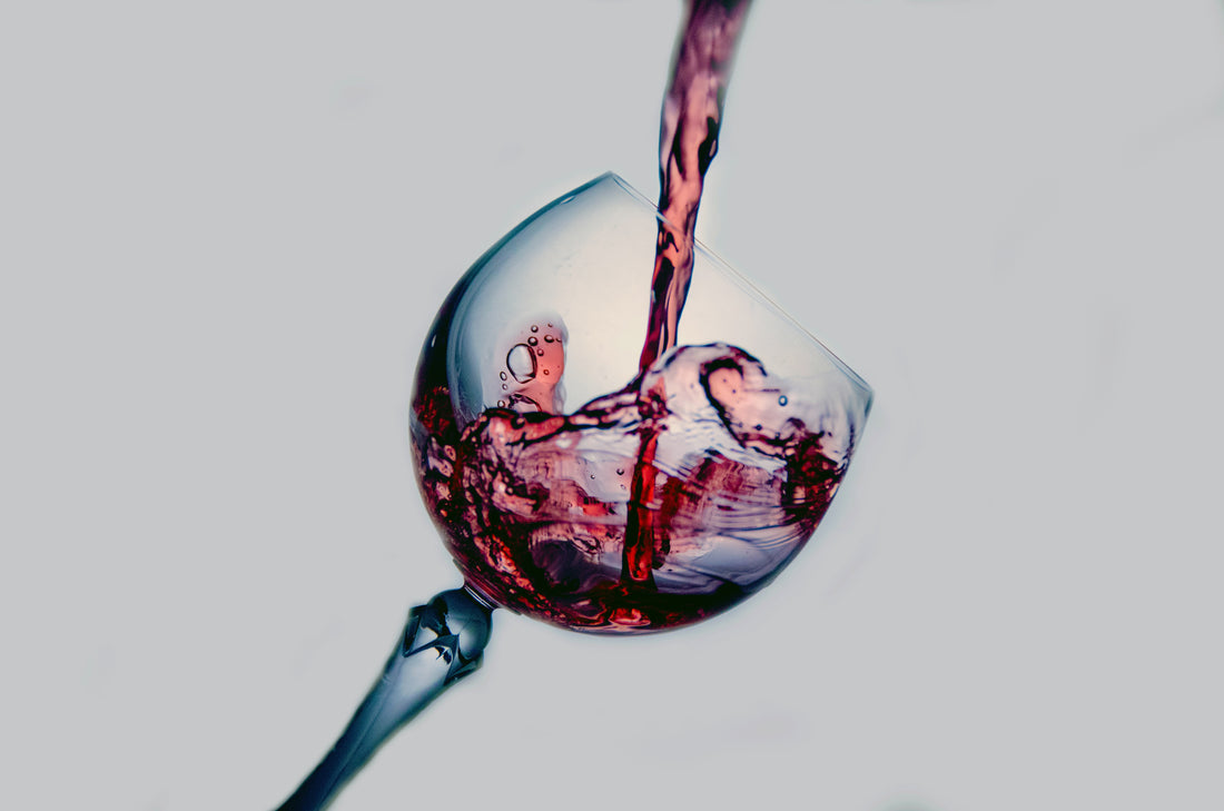 wine pouring into wine glass tilted at 45 degree angle to the right.