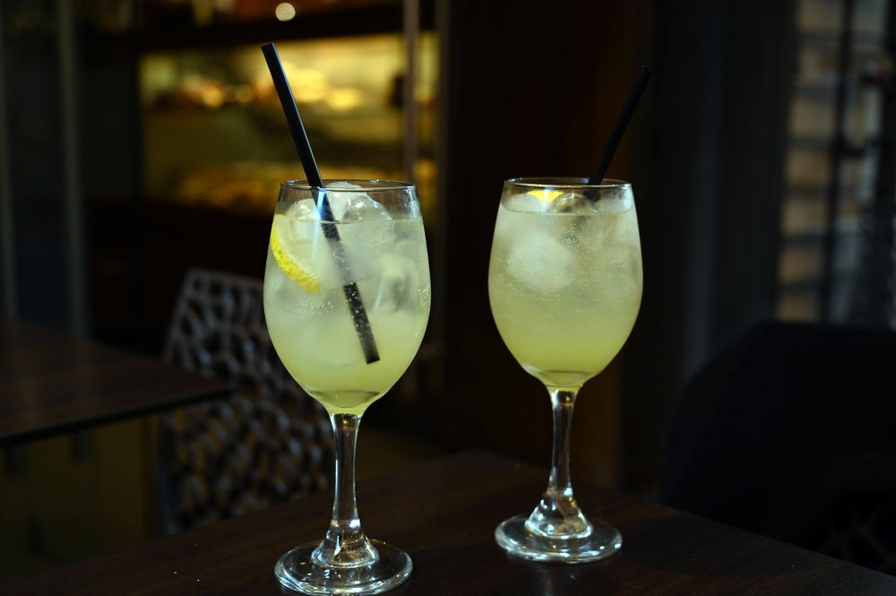 two glasses of limoncello with ice and straws in a bar