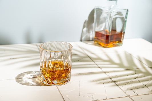 glass of whiskey on table with glass whiskey container